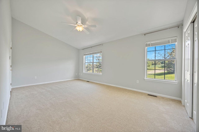 unfurnished room with vaulted ceiling, ceiling fan, visible vents, and light carpet