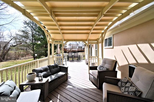 wooden terrace with outdoor dining area and outdoor lounge area