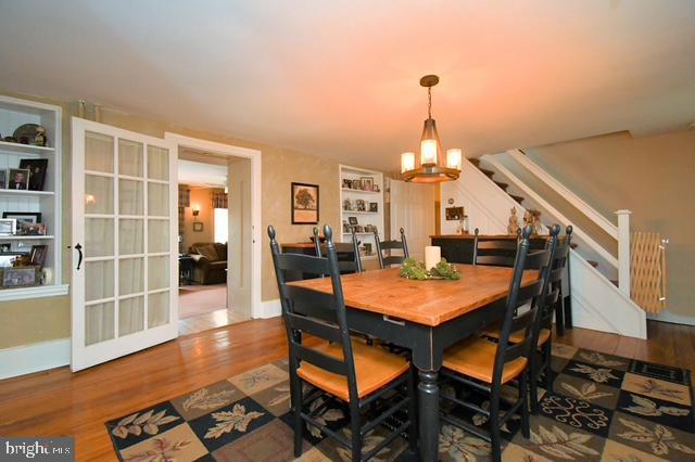 dining room with baseboards, wood finished floors, and stairway