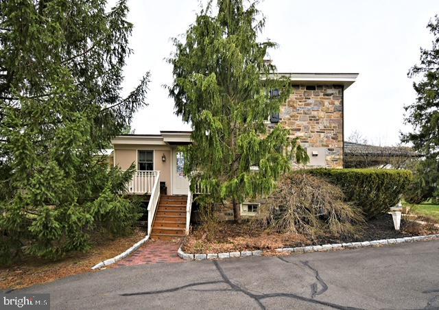 obstructed view of property with stone siding and stairs