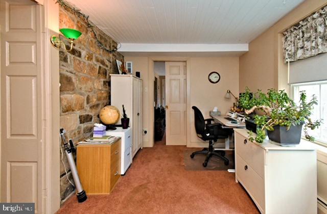 office space with light carpet and a baseboard radiator