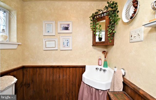 bathroom with a wainscoted wall