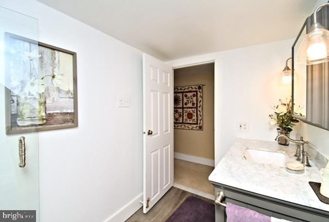 bathroom featuring baseboards, vanity, and wood finished floors