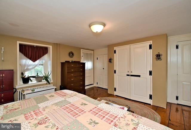 bedroom featuring two closets and wood finished floors