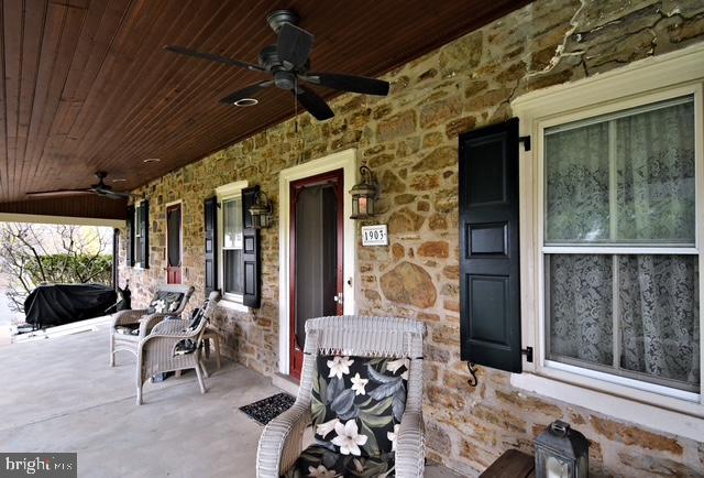 view of patio featuring a ceiling fan and a porch