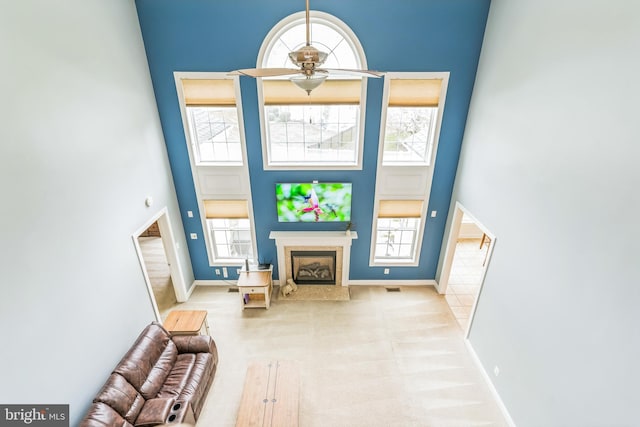 41430 Whimsical Ct, Leonardtown, MD 20650 - living area featuring a high end fireplace, baseboards, a towering ceiling, and ceiling fan
