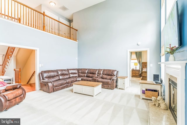 41430 Whimsical Ct, Leonardtown, MD 20650 - living area featuring stairway, a glass covered fireplace, a towering ceiling, carpet flooring, and visible vents