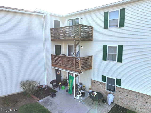 rear view of house featuring a patio area and a balcony