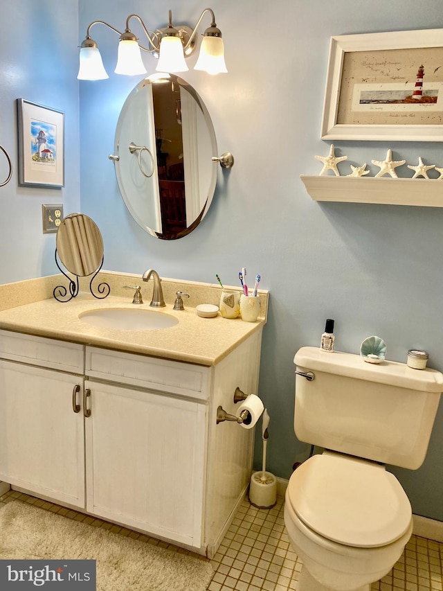 bathroom featuring toilet, vanity, and tile patterned flooring