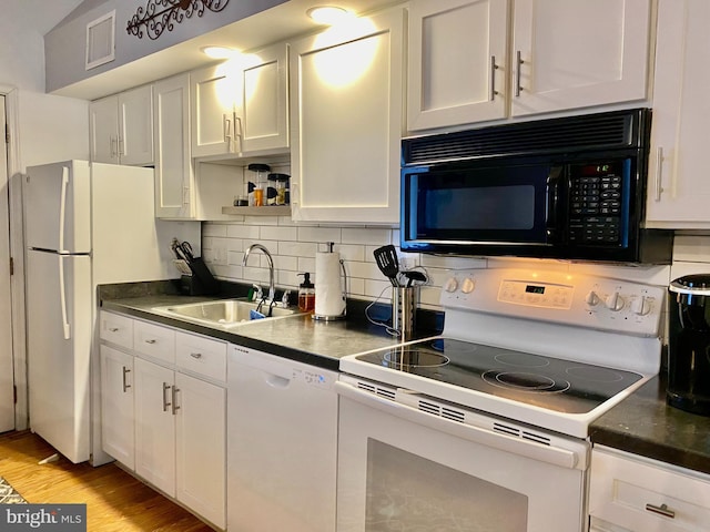 kitchen with tasteful backsplash, white appliances, white cabinetry, visible vents, and a sink