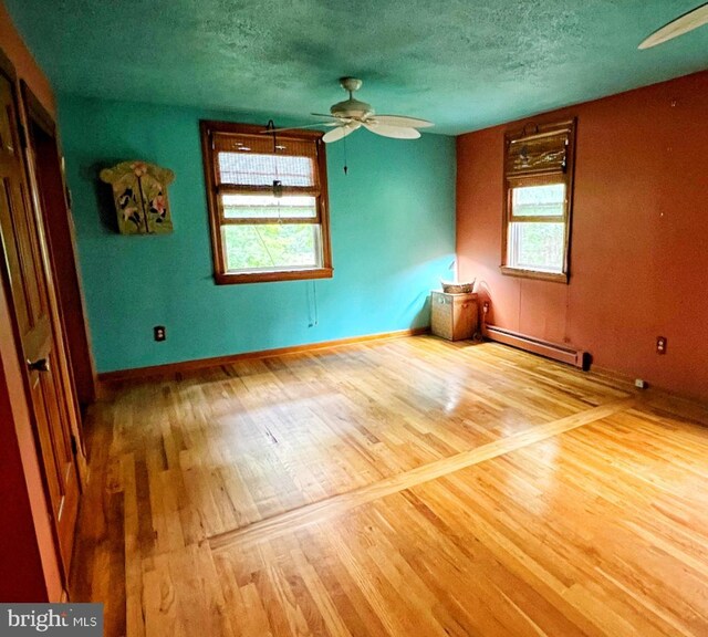 3080 Beautiful Run Rd, Orange, VA 22960 - unfurnished room with a baseboard heating unit, ceiling fan, wood finished floors, baseboards, and a textured ceiling