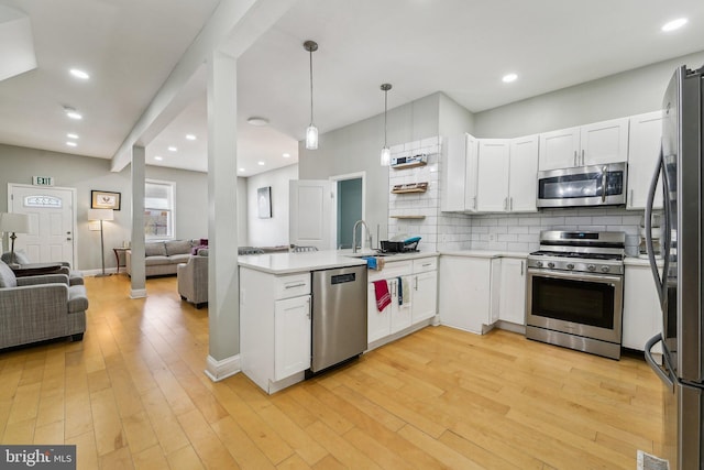 2519 Reisterstown Rd, Baltimore, MD 21217 - kitchen featuring appliances with stainless steel finishes, open floor plan, a peninsula, backsplash, and white cabinetry