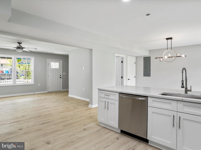 kitchen with light stone counters, a sink, dishwasher, light wood finished floors, and white cabinetry