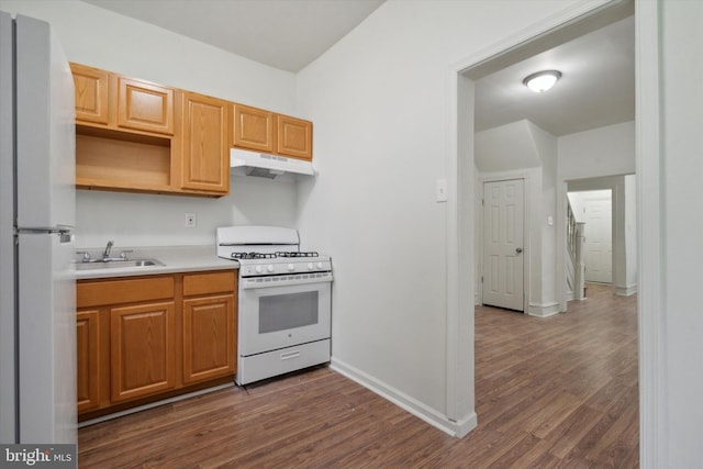 5449 Race St, Philadelphia, PA 19139 - kitchen featuring white appliances, dark wood-style floors, light countertops, under cabinet range hood, and a sink