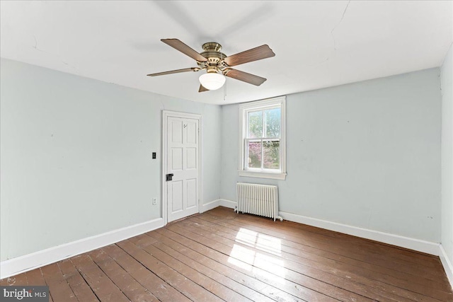 empty room featuring radiator, wood-type flooring, baseboards, and ceiling fan