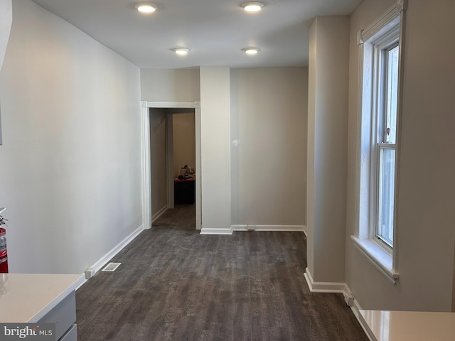 interior space with baseboards, plenty of natural light, dark wood-style floors, and visible vents