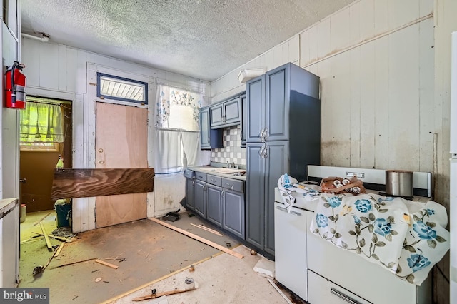 kitchen with a textured ceiling, gray cabinets, a healthy amount of sunlight, and a sink
