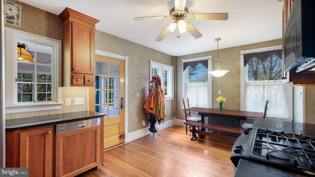 kitchen featuring paneled dishwasher, brown cabinets, black microwave, decorative backsplash, and light wood-type flooring