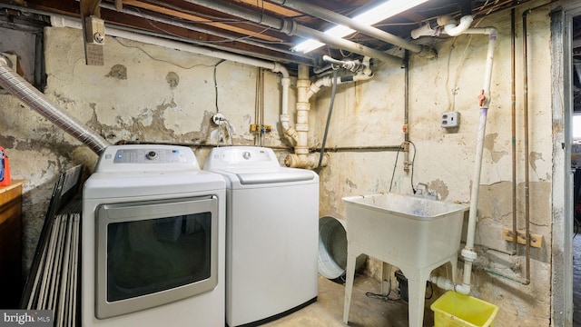 laundry area featuring washing machine and clothes dryer, a sink, and laundry area