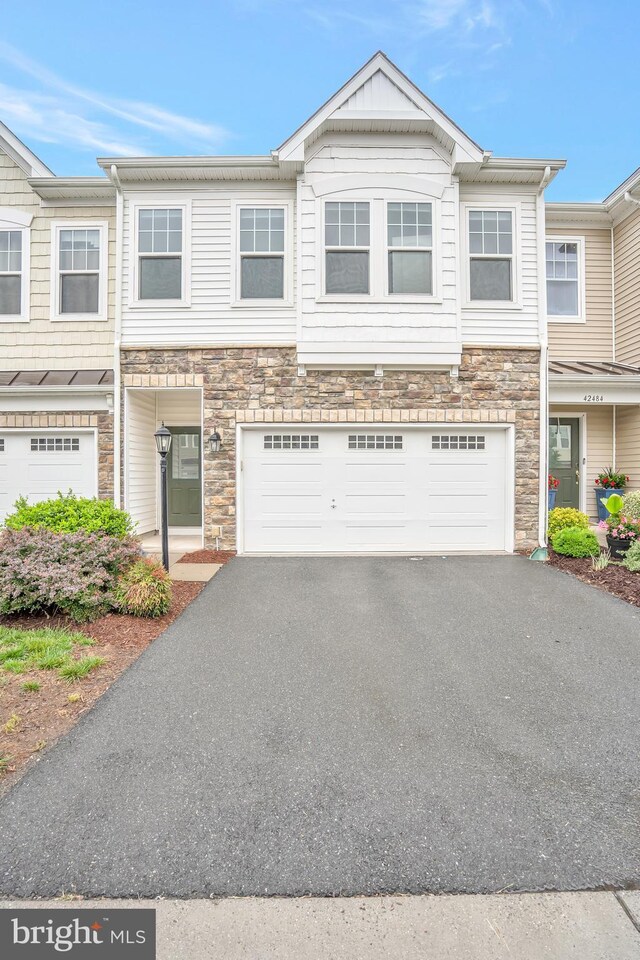 42482 Benfold Sq, Ashburn, VA 20148 - townhome / multi-family property featuring stone siding, driveway, and a garage