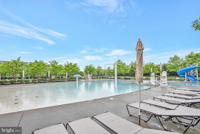 42482 Benfold Sq, Ashburn, VA 20148 - community pool featuring a water slide, a patio, view of wooded area, and fence