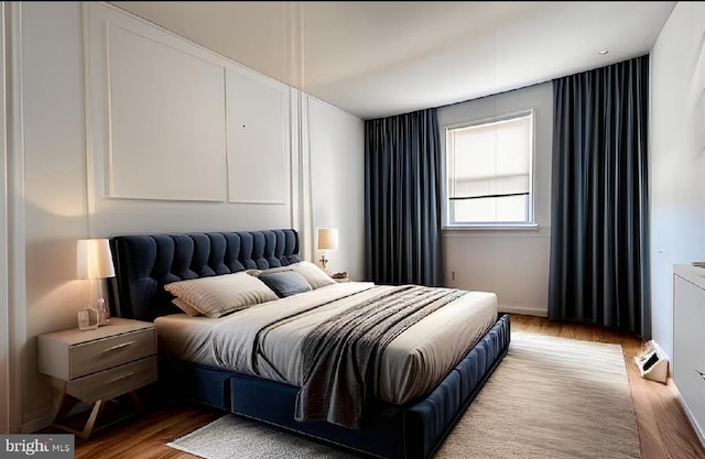 bedroom with baseboards and wood finished floors