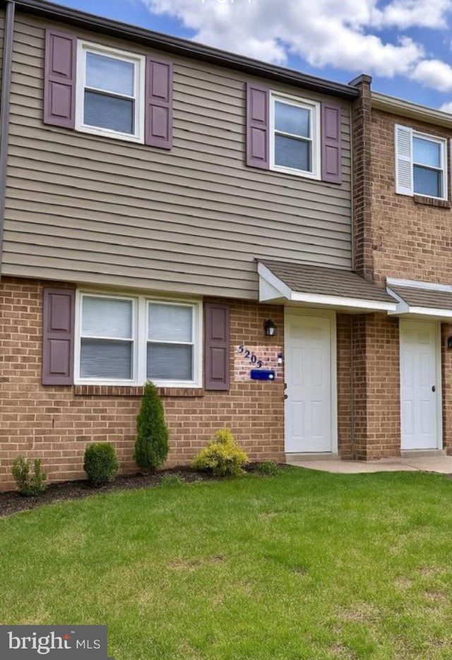view of front of property with brick siding and a front lawn