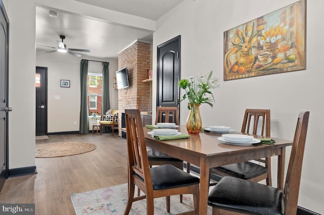 dining room with a ceiling fan, baseboards, and light wood-type flooring