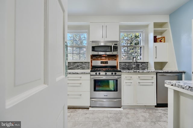 1122 Bellemore Rd, Baltimore, MD 21210 - kitchen featuring stainless steel appliances, light stone countertops, white cabinets, and a sink
