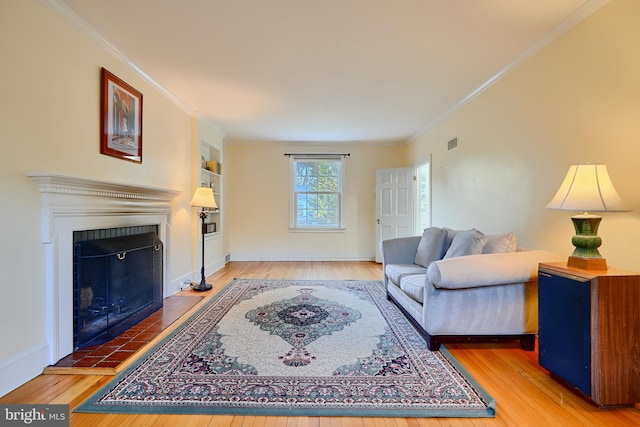 1122 Bellemore Rd, Baltimore, MD 21210 - living room featuring crown molding, a tiled fireplace, and hardwood / wood-style flooring