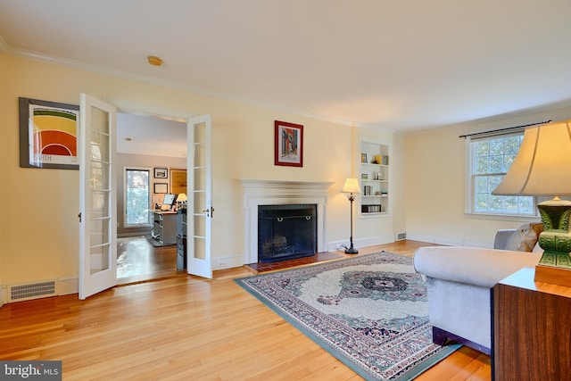 1122 Bellemore Rd, Baltimore, MD 21210 - living area with a fireplace, french doors, crown molding, light wood-style floors, and visible vents