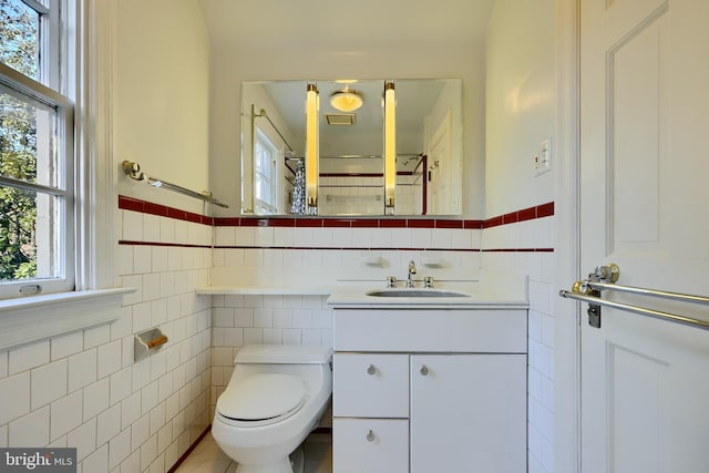 1122 Bellemore Rd, Baltimore, MD 21210 - bathroom featuring vanity, tile patterned floors, toilet, a wainscoted wall, and tile walls