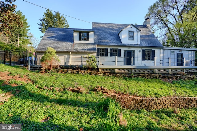 1122 Bellemore Rd, Baltimore, MD 21210 - rear view of house featuring a yard, fence, a deck, and a chimney