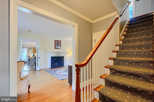 1122 Bellemore Rd, Baltimore, MD 21210 - stairway featuring a fireplace with flush hearth, wood finished floors, baseboards, and ornamental molding
