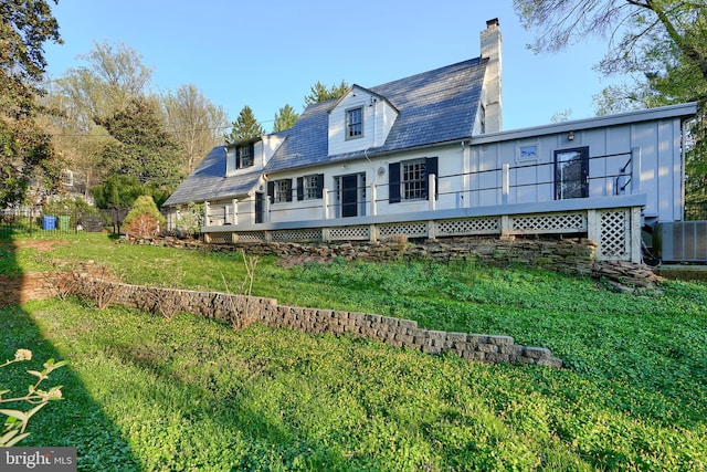1122 Bellemore Rd, Baltimore, MD 21210 - rear view of house with central AC unit, a wooden deck, a chimney, and a lawn