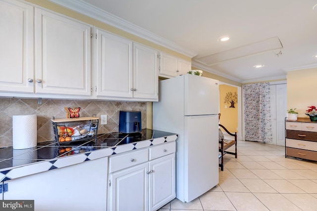 26039 Hidden Acres Ln, Millsboro, DE 19966 - kitchen featuring crown molding, freestanding refrigerator, light tile patterned floors, tasteful backsplash, and white cabinets