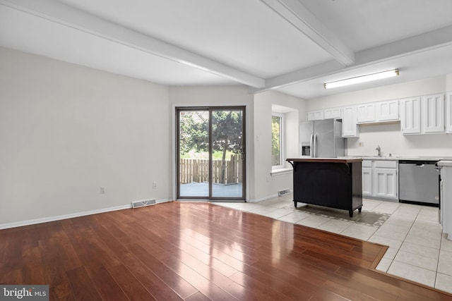 3 Bennington Pl, Newtown, PA 18940 - kitchen with light wood-type flooring, white cabinets, visible vents, beamed ceiling, and appliances with stainless steel finishes