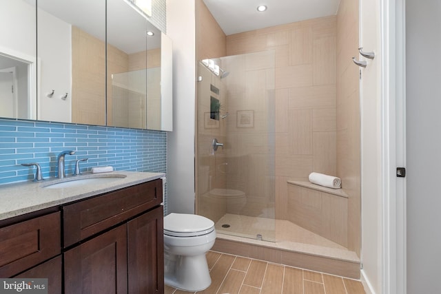 3883 Connecticut Ave NW Unit 909, Washington, DC 20008 - bathroom featuring tasteful backsplash, tiled shower, toilet, vanity, and wood finished floors