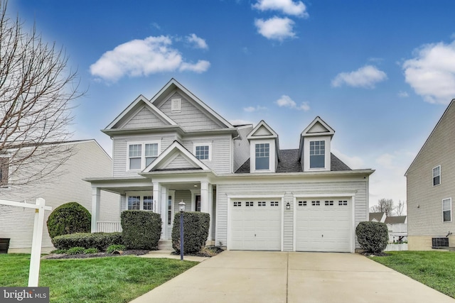 craftsman inspired home featuring concrete driveway, covered porch, and a front lawn