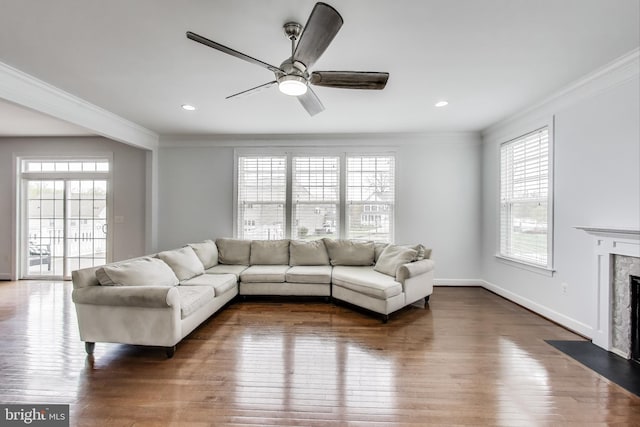 living room with dark wood-type flooring, crown molding, and plenty of natural light
