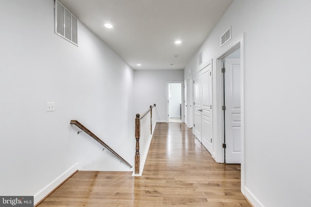 hallway with recessed lighting, an upstairs landing, visible vents, and light wood-type flooring