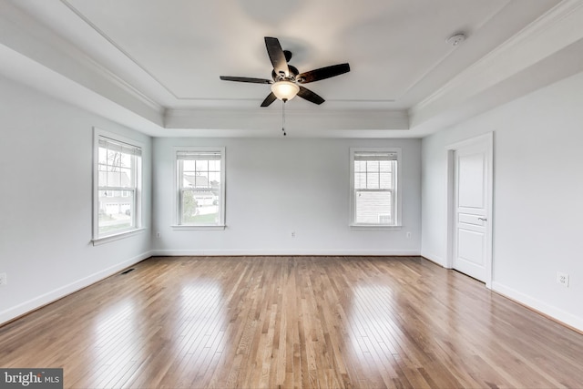 unfurnished room with a tray ceiling, crown molding, and ceiling fan