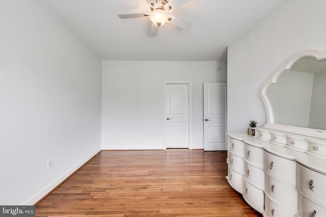 unfurnished bedroom with light wood-type flooring, ceiling fan, and baseboards