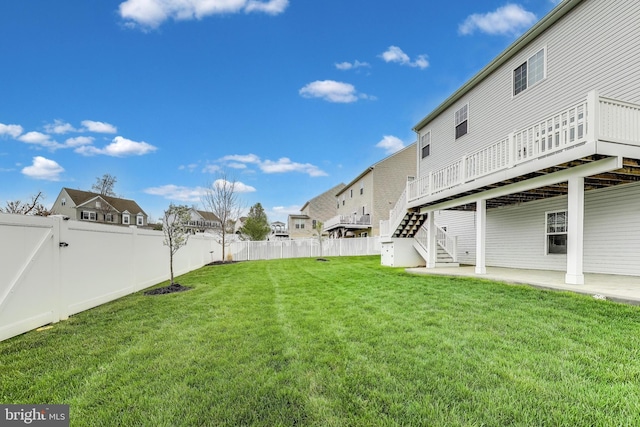 view of yard featuring a residential view, stairway, a fenced backyard, a deck, and a gate