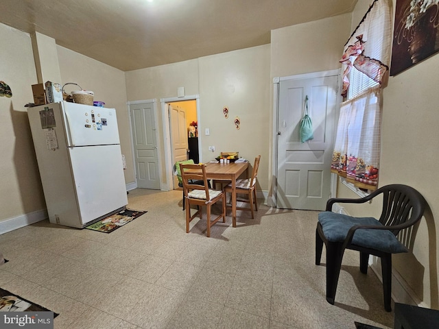 dining space with baseboards and light floors