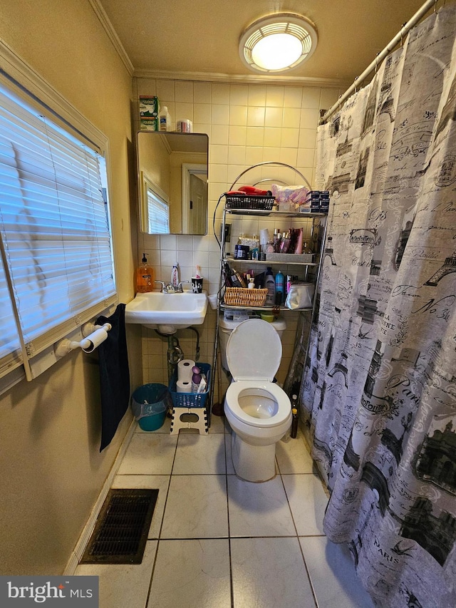 bathroom featuring ornamental molding, visible vents, tile patterned flooring, a sink, and tile walls