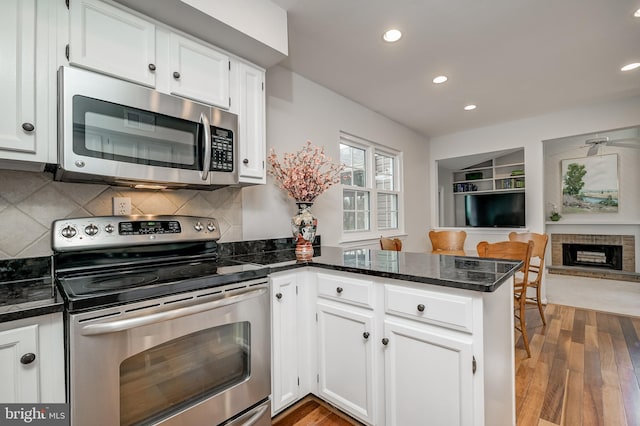 10 Fullview Ct, Gaithersburg, MD 20878 - kitchen featuring stainless steel appliances, a peninsula, open floor plan, recessed lighting, and white cabinetry