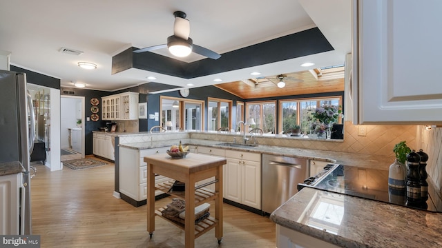 kitchen featuring a healthy amount of sunlight, a sink, backsplash, and appliances with stainless steel finishes