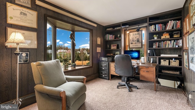 office featuring wood walls, carpet, and built in shelves