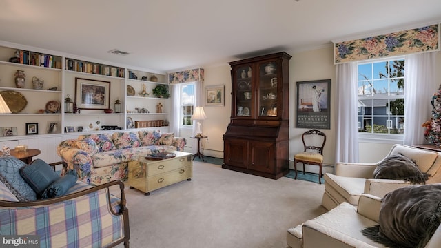 living room with ornamental molding, visible vents, a baseboard radiator, and light carpet